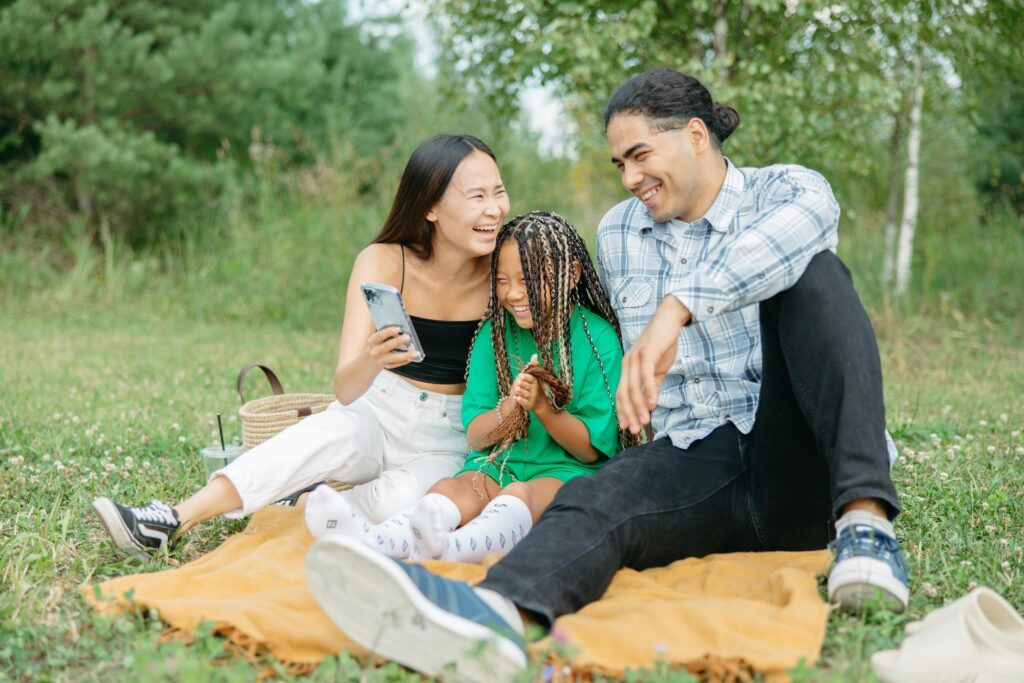 A joyful family enjoying a picnic together, capturing a moment of happiness and unity in a serene park setting.